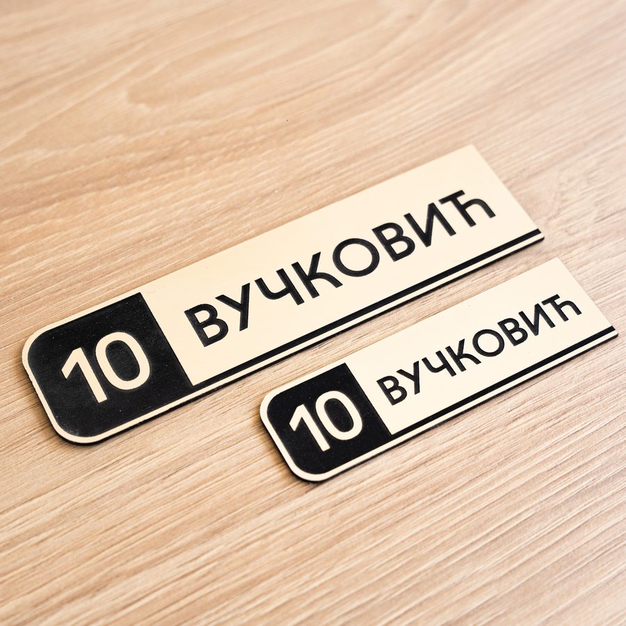 Crna pločica sa brojem 10 i prezimenom Вучковић
